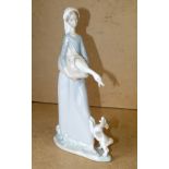 A Lladro Figure of a standing lady holdi