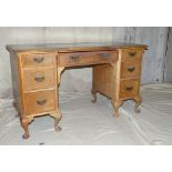 A Walnut Break Front Kneehole Writing Desk having green leather inset top, centre drawer flanked by
