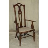 An Edwardian Mahogany Armchair having pierced back with overstuffed seat on round tapering legs