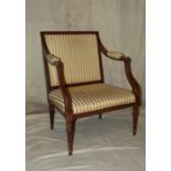 A Mahogany Armchair having striped overstuffed seat back and padded arms on round turned fluted