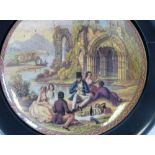 A China Pot Lid depicting figures having picnic on riverbank with ruins in background in loose