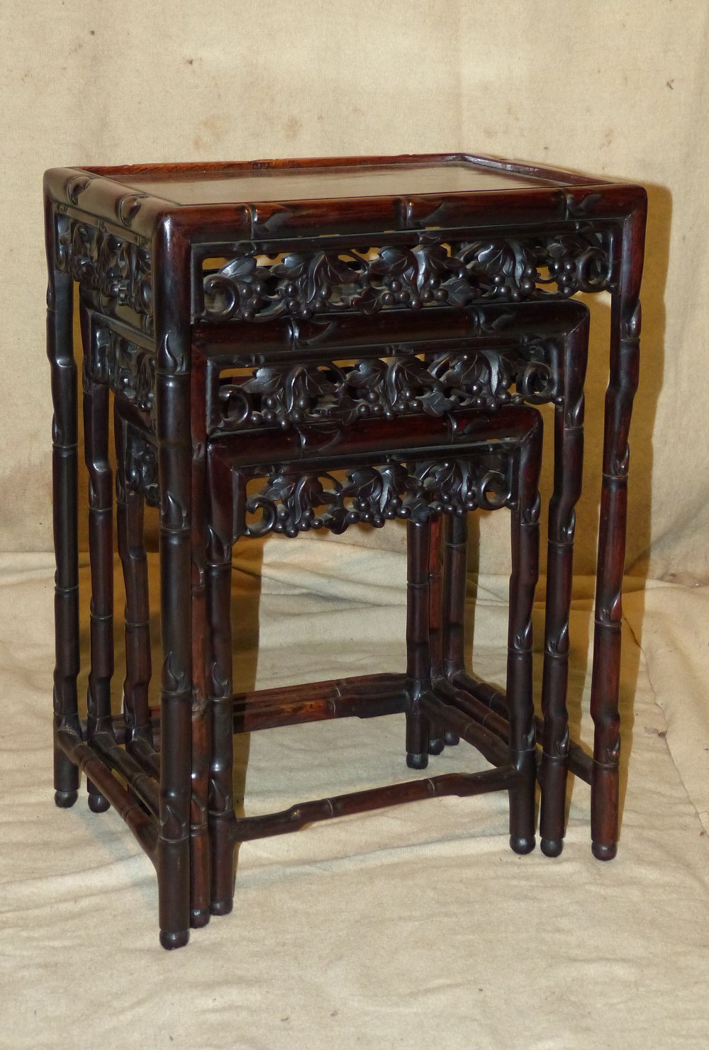 A Nest of 3 Oriental Rectangular Shaped Coffee Tables having carved fruit, leaf and bamboo