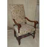 A Walnut Armchair having floral overstuffed seat and back, scroll arms on round turned legs with