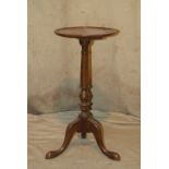 A Mahogany Round Wine Table having lipped rim, turned stem on 3 splayed legs, 63cm high
