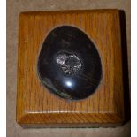 An Oak Rectangular Shape Paperweight inset with pebble mounted with silver kiwi motif,