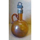 A 19th Century Brown Glass Bottle with stopper having loop handle,