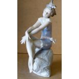 A Lladro Figure of a young seated girl in bathing suit,