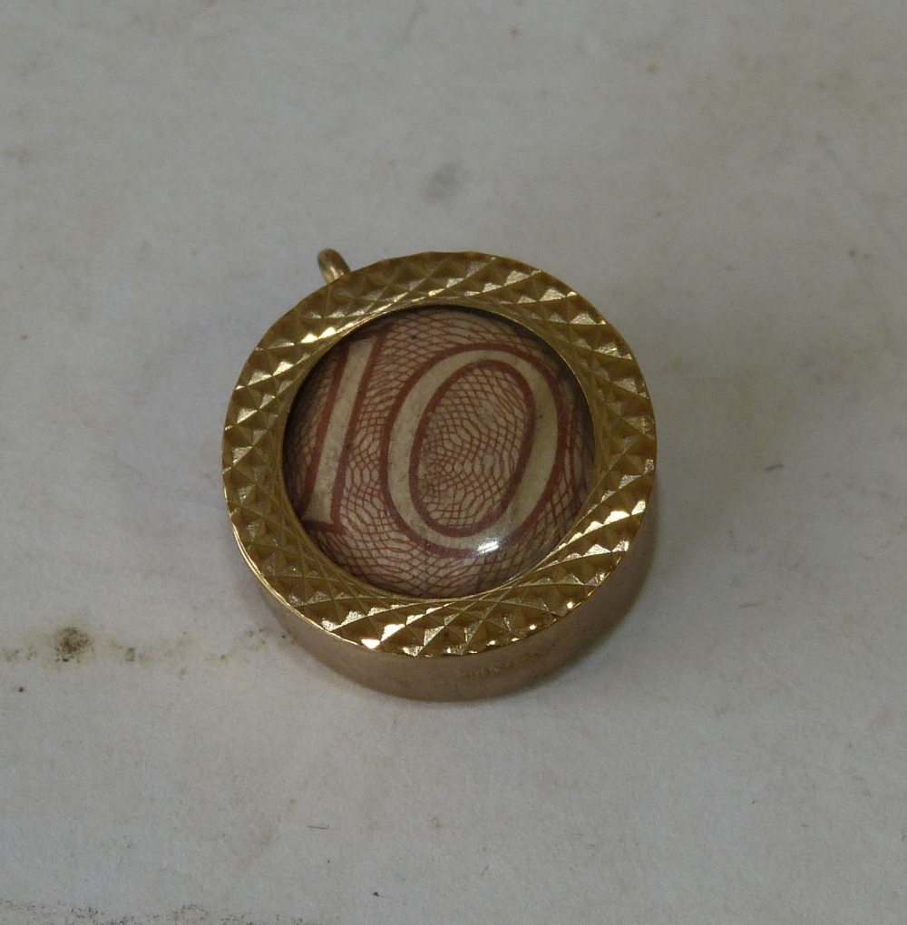 A 9ct Gold Circular Pendant Mounted with old 10 schilling note