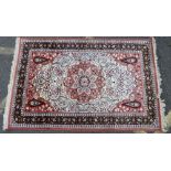 A Persian Rug on cream, red and blue ground having centre medallion,