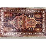 A Persian Rug on cream and brown ground having centre vase, vine and building decoration,