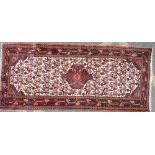 A Persian Runner on cream, red and green ground with centre medallion,