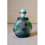 An Oriental Peking Style Glass Snuff Bottle on white and green ground having raised insect and