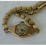 A 9ct Gold Ladies Watch having circular dial with Arabic numerals, having 9ct strap bracelet,
