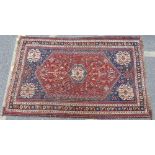 A Persian Rug on red, blue and cream ground having centre medallion, with corner medallions,