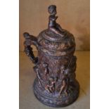 An Oval Lidded Tankard on brown ground with raised figure, tree, floral and scroll decoration,