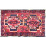 A Persian Rug on red and blue ground having 2 centre medallions,