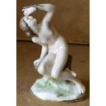 A Naples China Figure of a seated female nude holding a serpent,