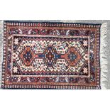 A Small Persian Prayer Rug on white, red and blue ground having 3 centre medallions,