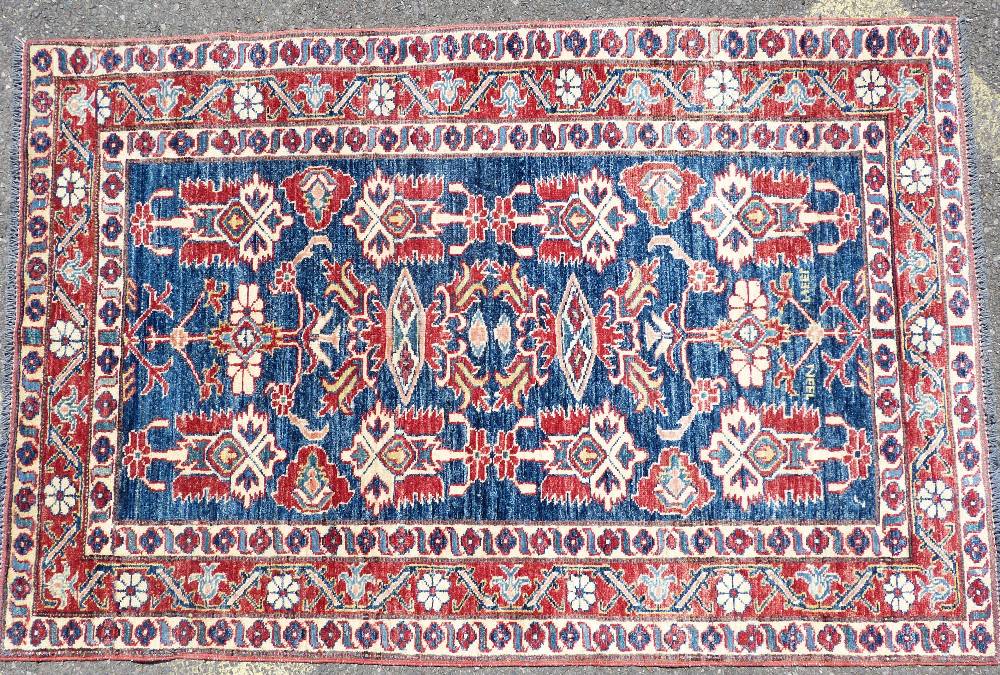 A Persian Rug on white, red and blue ground having various centre medallions,