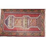 A Persian Rug on red, white and blue ground, having centre column medallion,