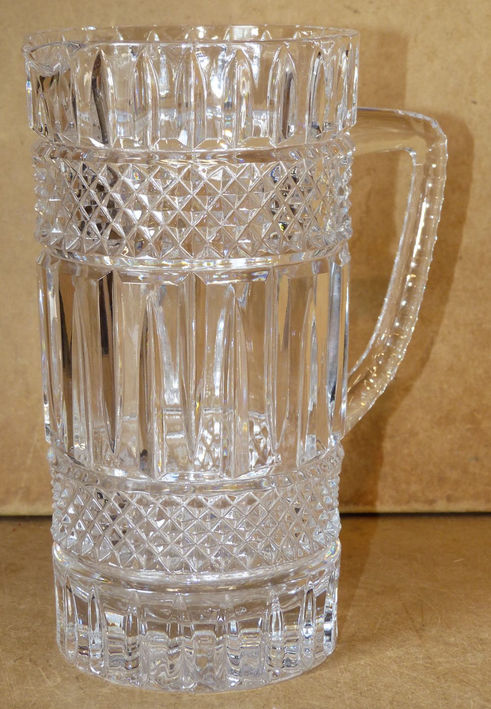 A Heavy Cut Glass Cylindrical Water Jug with tooth cut decoration,