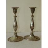 A Pair of Sterling Silver Oval Candlesticks having chamfer decoration on sweeping bases