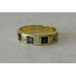 An 18ct Gold Ladies Ring set with 4 square sapphires interspersed by 3 diamonds