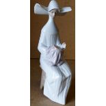 A Lladro Figure of a seated nun sewing, 20.