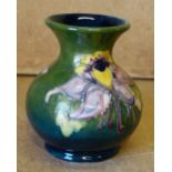 A Moorcroft Small Round Thin Neck Trumpet Shape Vase on green ground having coloured floral and