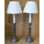 A Pair of Brass Table Lamps on turned reeded stems having round sweeping bases with shades,