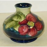 A Moorcroft Small Round Thin Neck Trumpet Shape Vase on blue and green ground with multicoloured