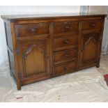 An Oak Dresser Base having 4 centre drawers flanked by 2 drawers and 2 panelled doors on style feet,