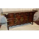 An Oriental Sideboard having scroll ends, 7 drawers and 2 panelled doors to centre,