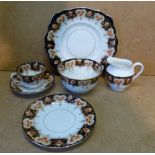 A Melba Tea Service on white and blue ground with multicoloured floral, leaf and gilt decoration,