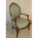 A 19th Century Walnut Spoon Back Arm Chair having gilt metal raised ribbon motif and ball edging,