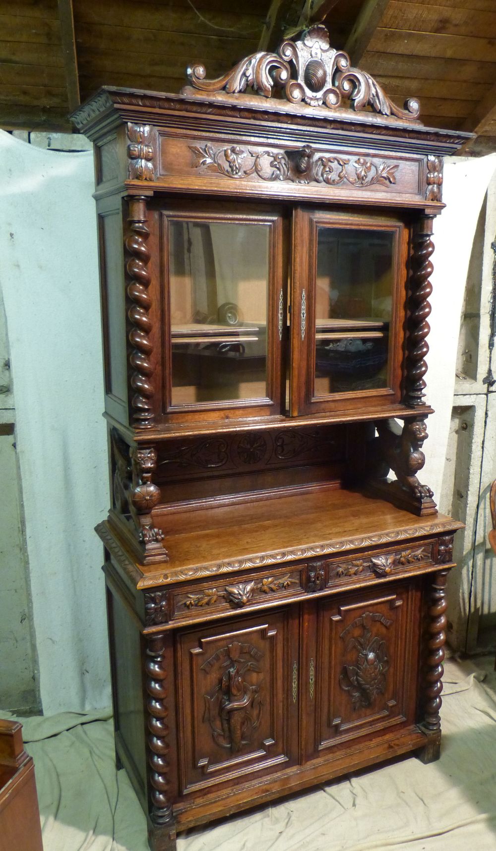 A Victorian Oak Bookcase having all over raised animal, shield, floral and scroll decoration,