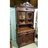 A Victorian Oak Bookcase having all over raised animal, shield, floral and scroll decoration,
