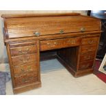 An Oak Roll Top Kneehole Desk, having cylinder top enclosing pigeon holes, centre drawer below,