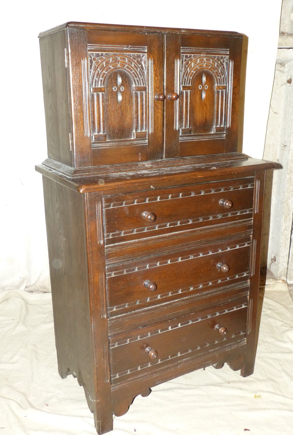 A Similar Oak Chest having 2 panelled doors with carved arched motifs above 3 long drawers with