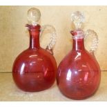 2 Cranberry Oval Bulbous Shaped Claret Jugs with stoppers having twist handles,