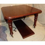 A Victorian Mahogany Key Wind Dining Table having 1 extra leaf on round turned legs with brass