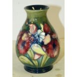 A Moorcroft Small Bulbous Thin Neck Trumpet Shape Vase on green ground with multicoloured floral