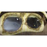 A pair of gilt metal oval wall mirrors,