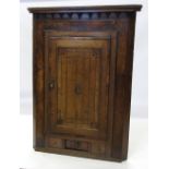 A late Georgian oak corner cupboard, hav