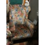 A wing back armchair, raised on short ta