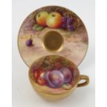 A Royal Worcester miniature cabinet cup and saucer, the saucer hand painted with fruit to a mossy