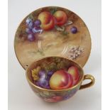 A Royal Worcester cabinet cup and saucer, the cup interior and exterior hand painted with fruit to a