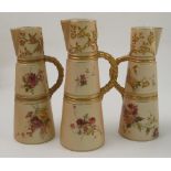 Three Royal Worcester blush ivory claret jugs, with moulded handles, decorated with flowers, dated