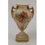 A Royal Worcester blush ivory pedestal vase, with gilt handles and moulding, decorated with floral