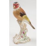 A Royal Worcester model, Goldfinch, on a gilt and white stump decorated with flowers, model number